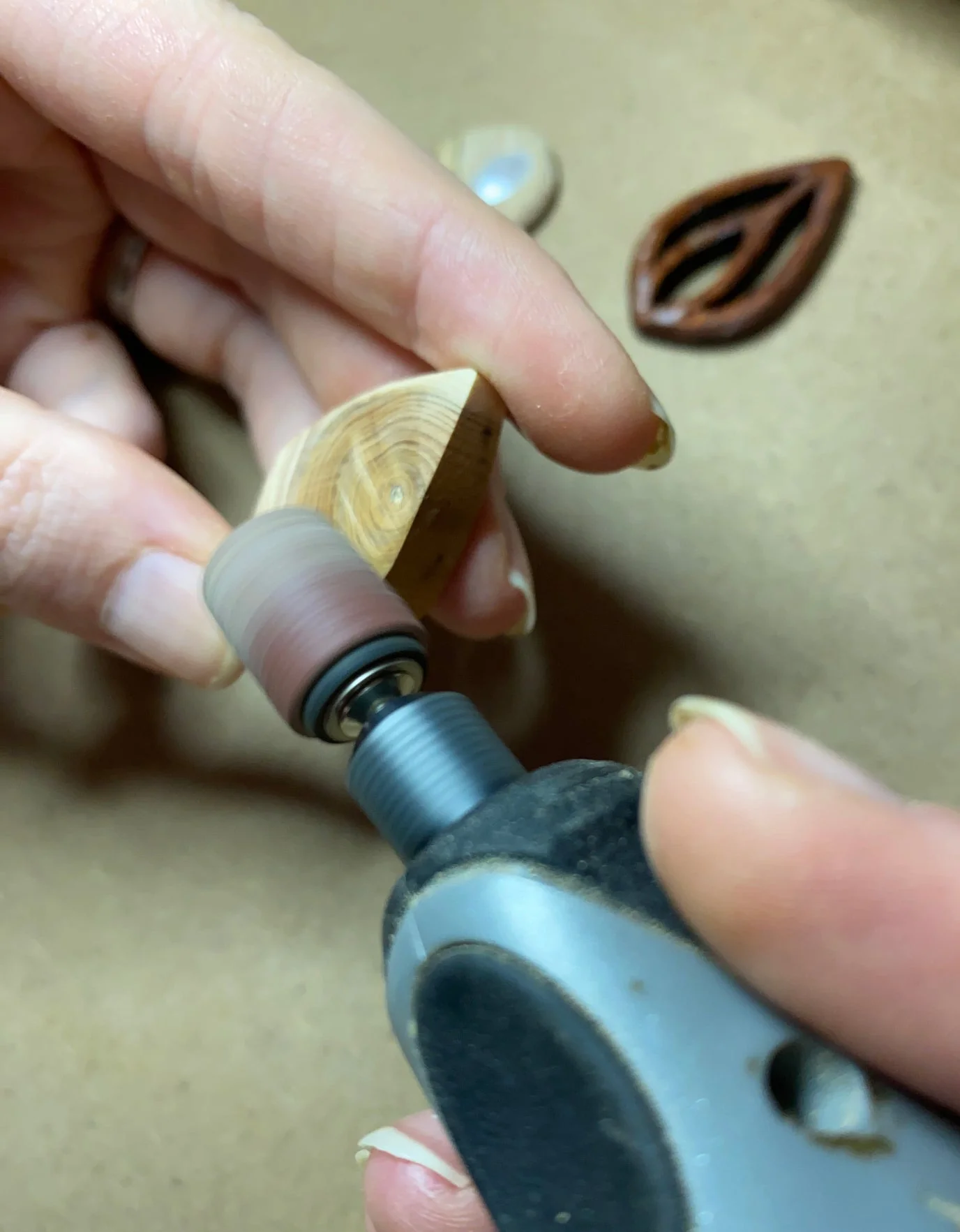 Ein Holzstück wird mit einem Schleifaufsatz in Form geschliffen